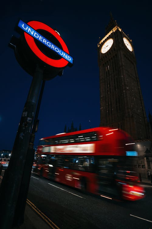 Red Double-Decker Bus Dashing past Big Ben and Night