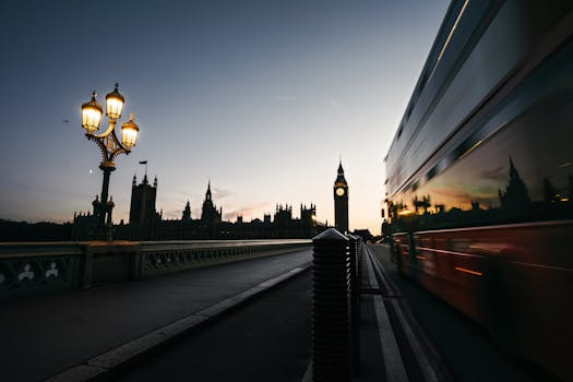 Dramatic shot of Big Ben and a double-decker bus on Westminster Bridge at dusk.