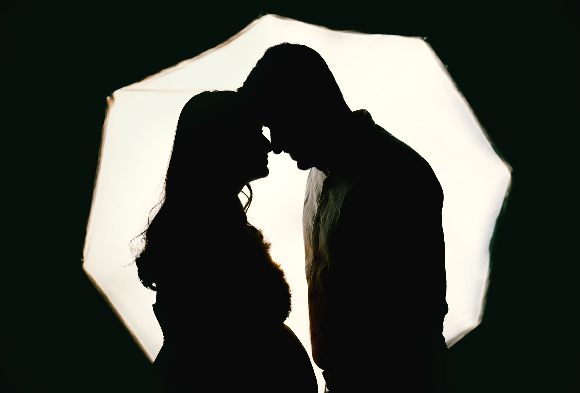 Silhouette of a couple sharing an intimate moment, symbolizing love and connection.