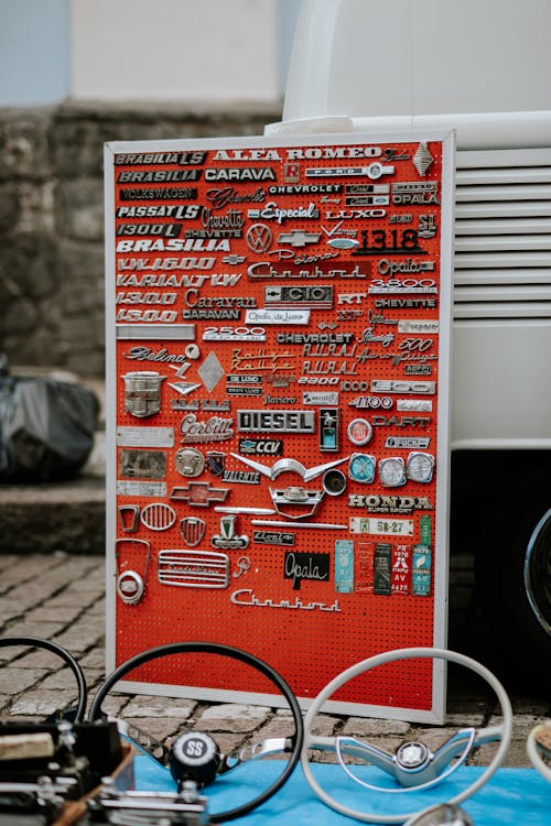 Car Brand Logos and Vintage Steering Wheels Displayed at a Flea Market