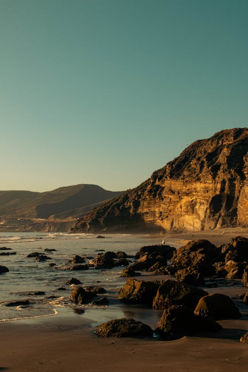 Scenic Hilly Seashore Landscape with Stones Lying on a Sandy Beach