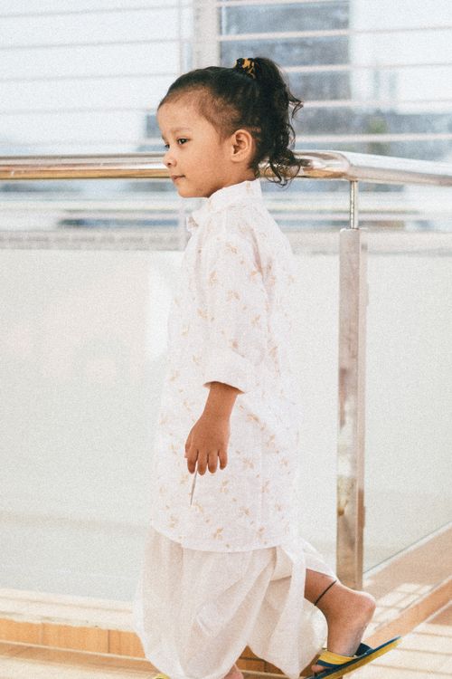 Free A young girl in traditional attire walking indoors, capturing a serene moment. Stock Photo
