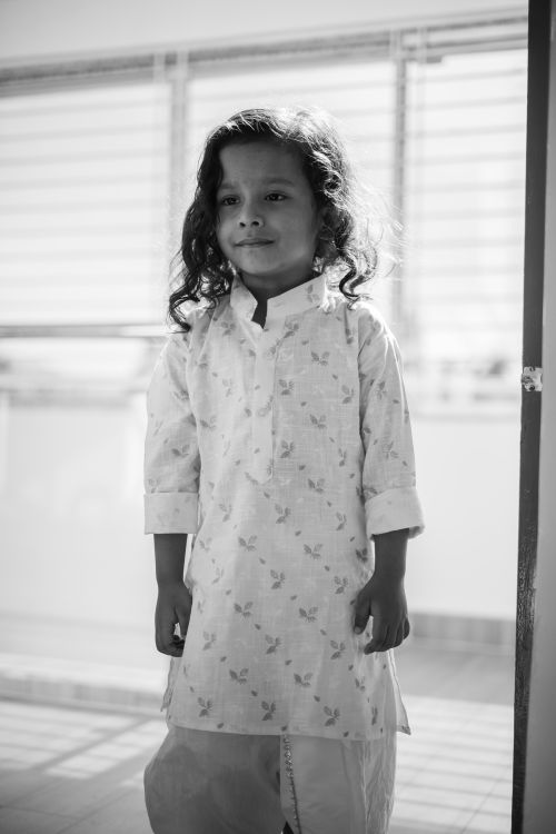 Free Black and white portrait of a smiling Indian girl in traditional attire, standing indoors. Stock Photo