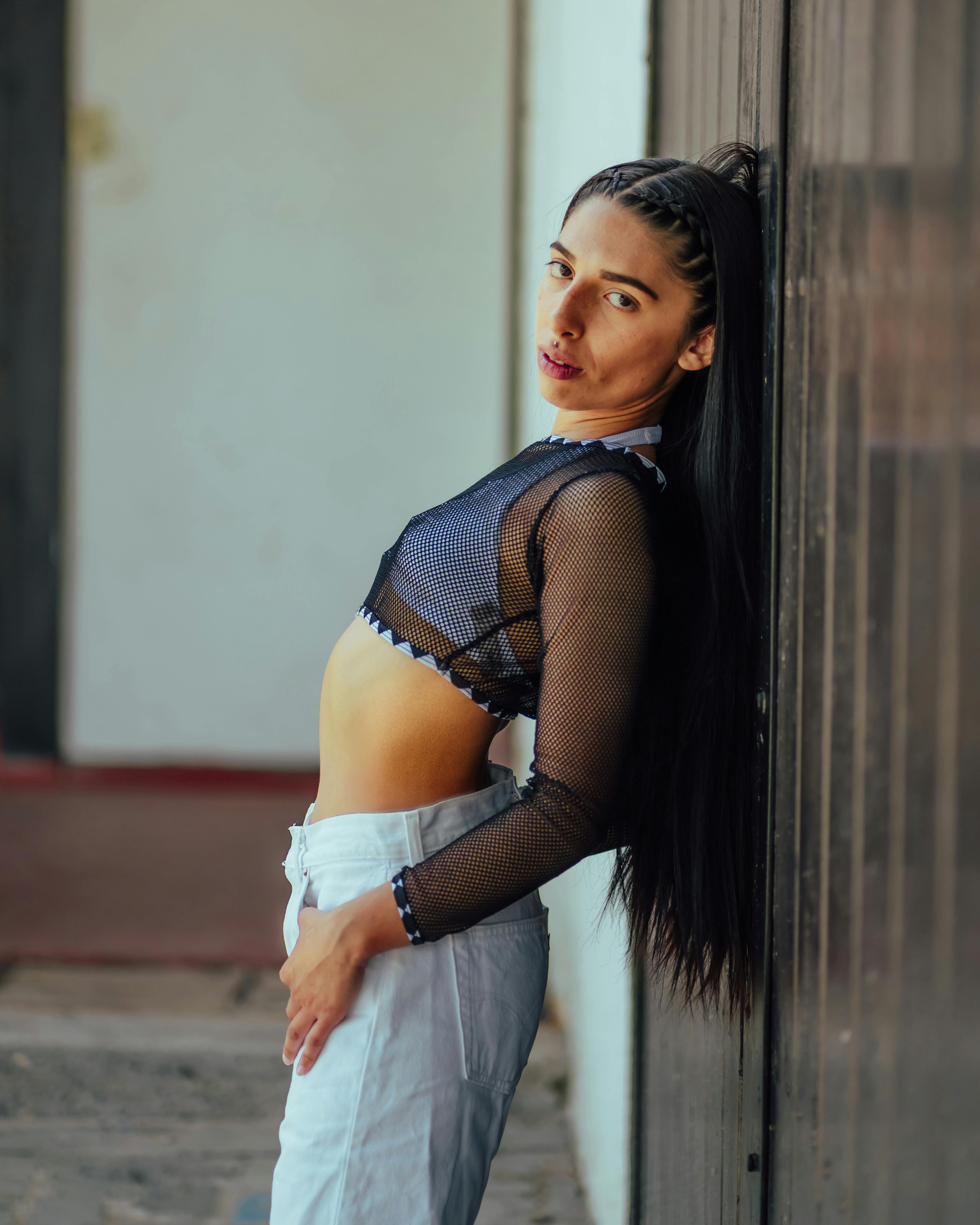 Young Brunette Woman in Black Mesh Crop Top Posing by a Wall · Free Stock  Photo