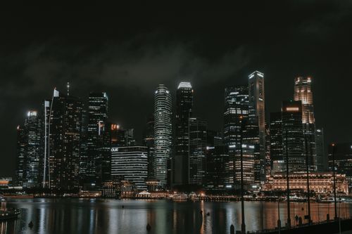 Free Captivating view of Singapore's iconic skyline at night with skyscrapers reflecting on Marina Bay. Stock Photo