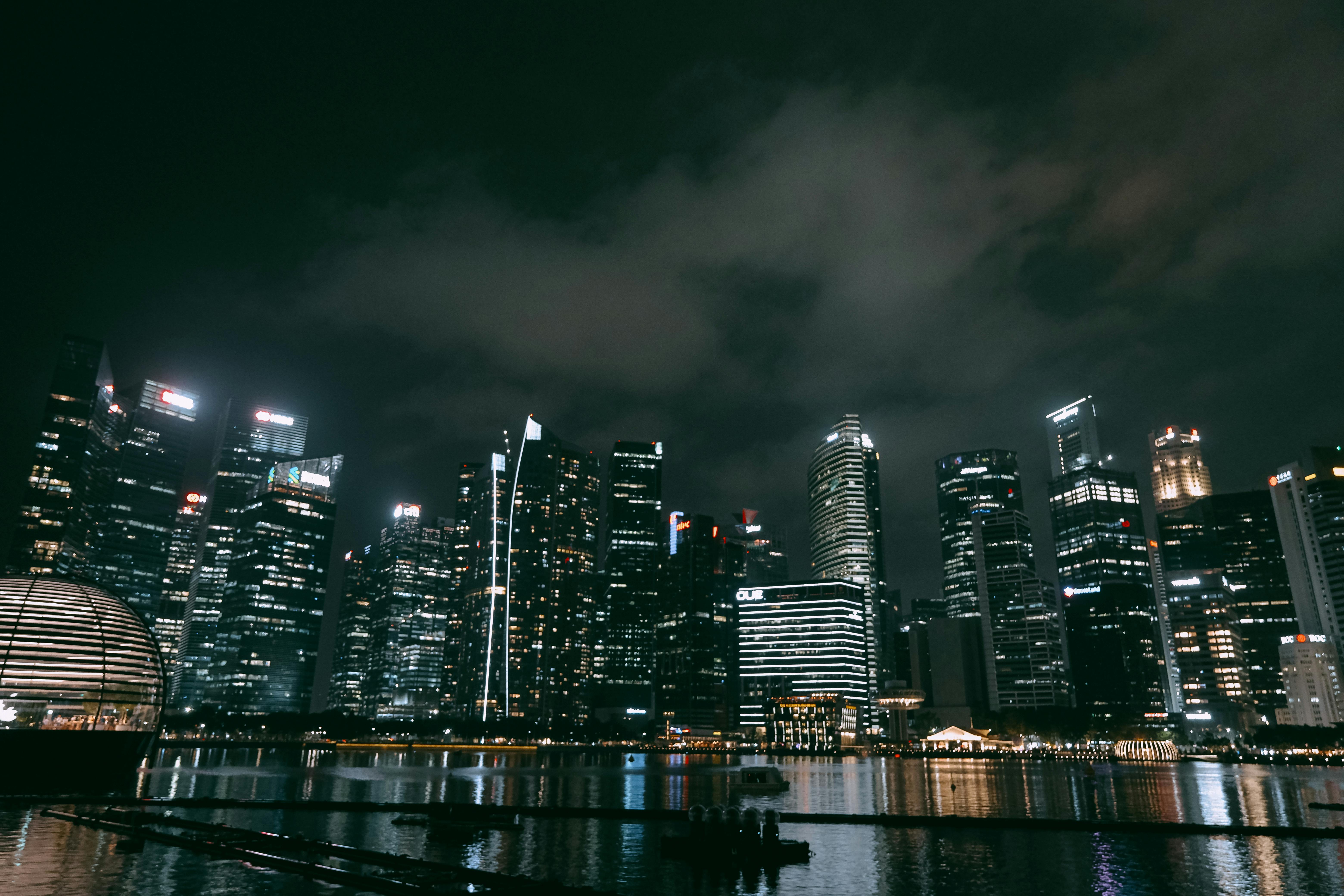 A stunning view of Singapore's skyline at night with illuminated skyscrapers and reflections.