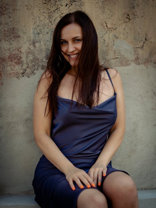Smiling Woman Sitting in Dress