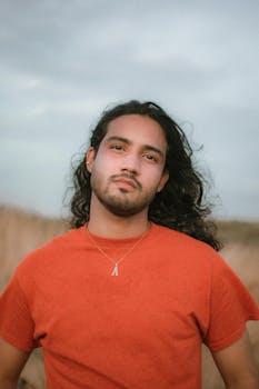 Portrait of a young man wearing a red shirt and necklace in Punto Fijo, Venezuela.