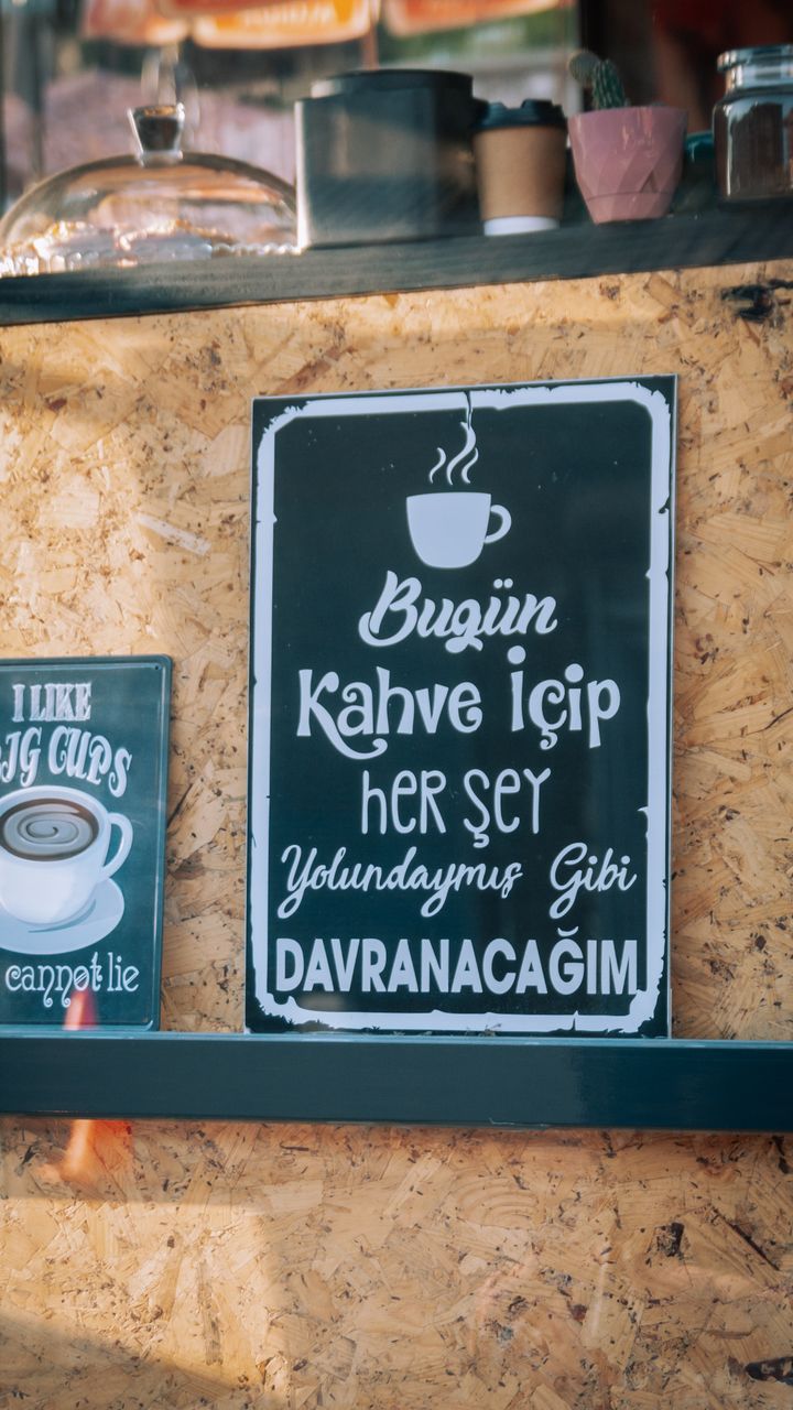 Framed chalkboard sign mounted above a coffee bar hutch