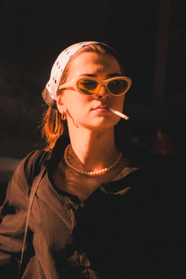 Young Woman In Black Shirt And White Polka Dot Headscarf Posing With A Cigarette