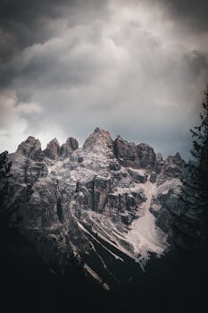 在多云的天空下，日落时分的雄伟山峰非常适合冒险和旅行主题