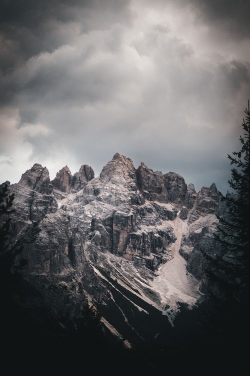Free Majestic mountain peak under cloudy sky at sunset, perfect for adventure and travel themes. Stock Photo