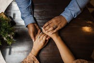 一对夫妇牵着手坐在木桌旁，表达着爱与联系