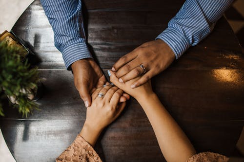 Mains enlacées sur table en bois