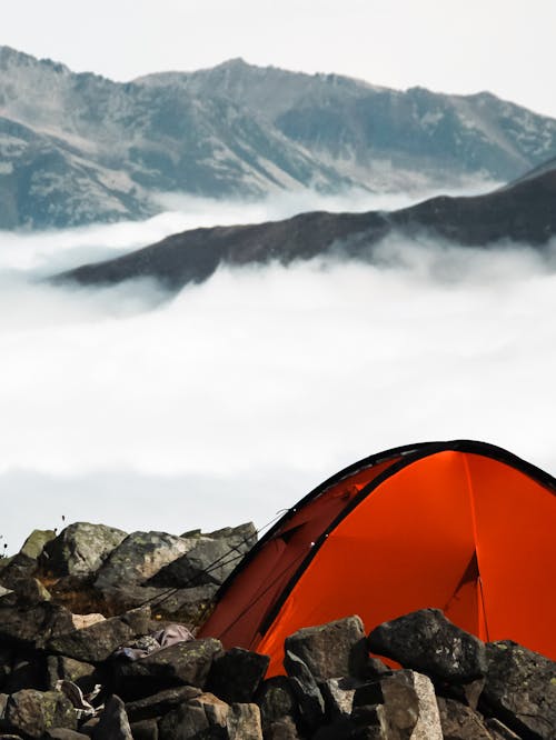 Cloud behind Tent on Rocks in Mountains