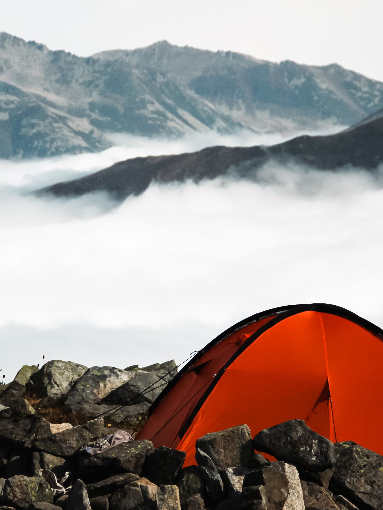 An ultralight tent pitched on exposed rocky mountain terrain, illustrating why wind resistance matters more than raw weight