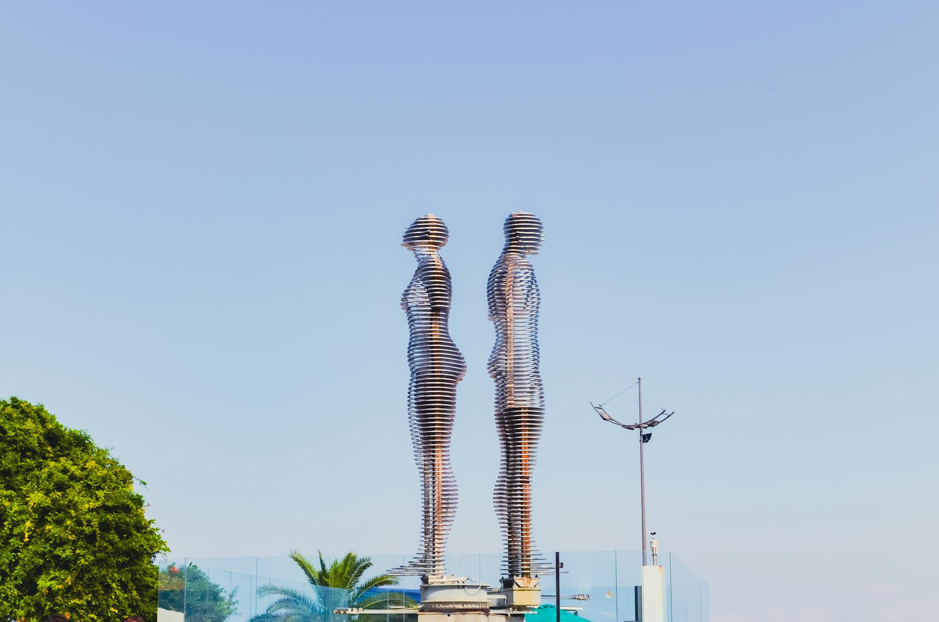 Captivating Ali and Nino metal sculpture against a clear blue sky in Batumi, Georgia's urban landscape.