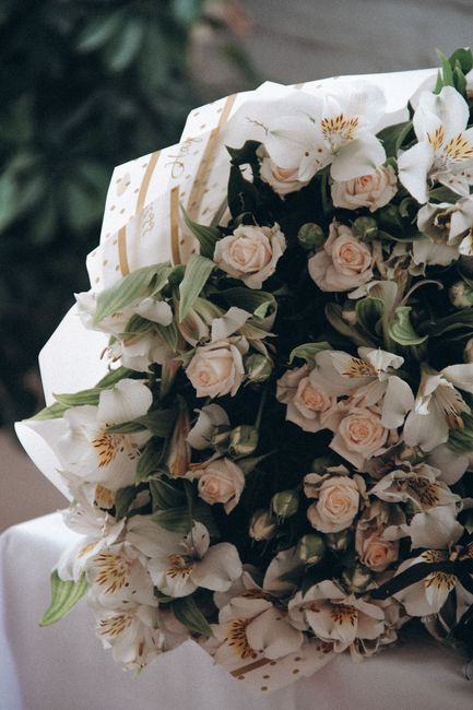 Close-up of an elegant bouquet featuring white roses and greenery, perfect for gift or decoration.