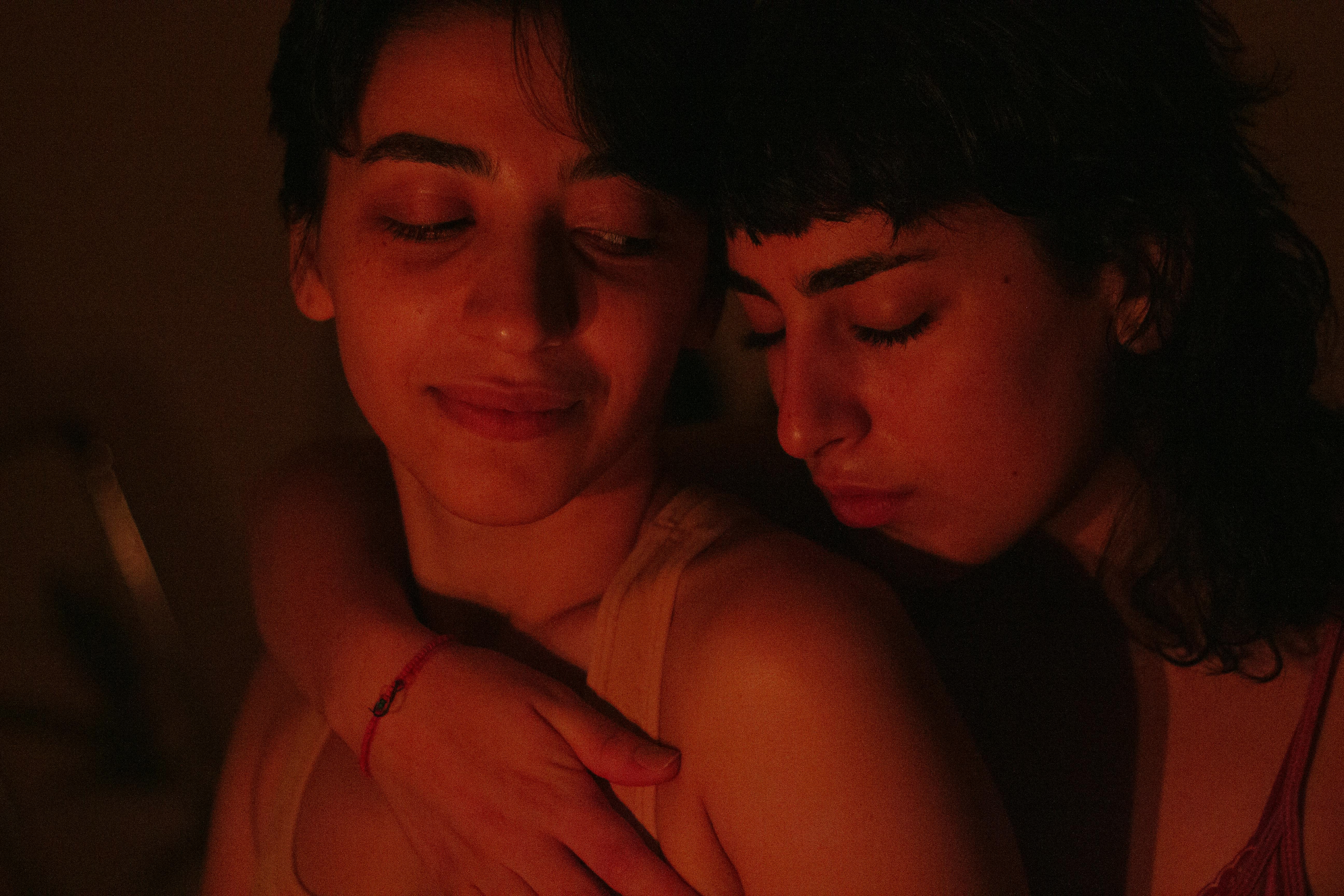 A warm, intimate embrace between two women, capturing a moment of affection and connection.