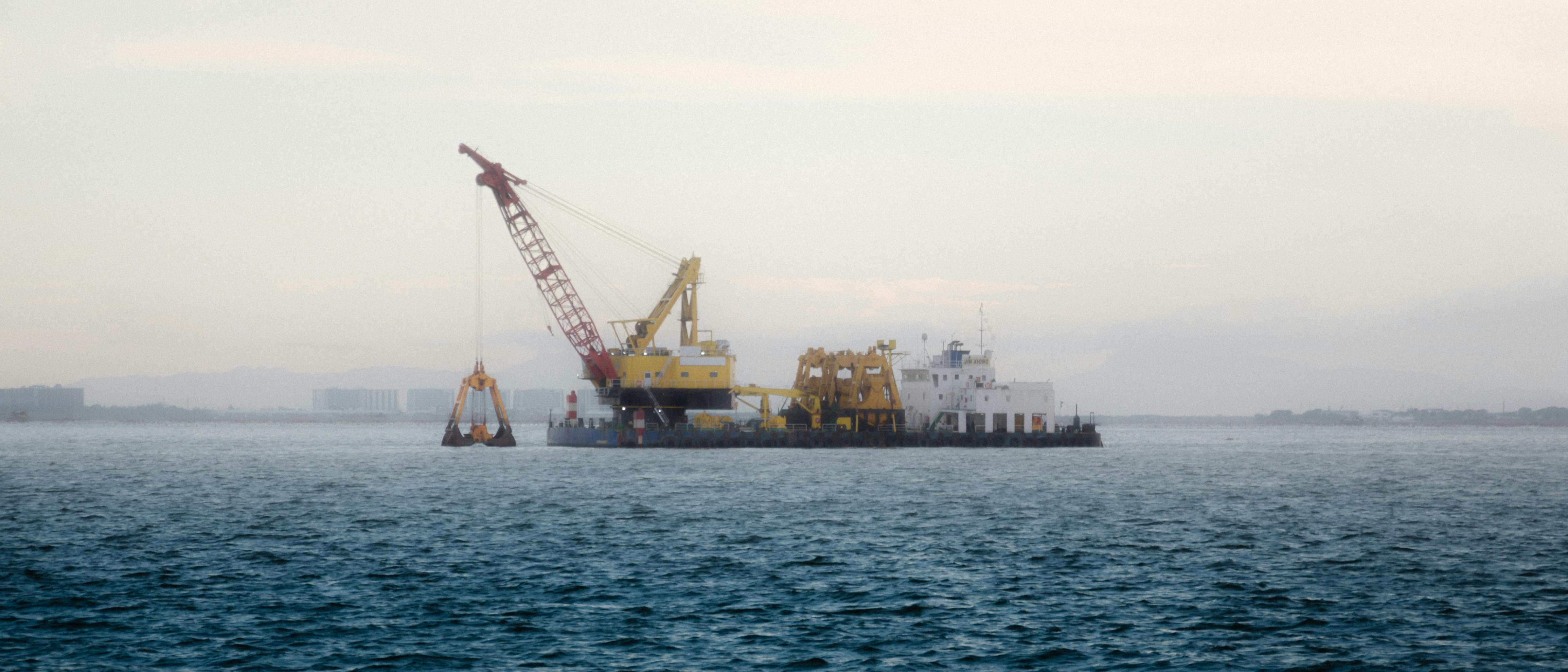 A construction barge on a calm ocean near the Philippines during early morning.