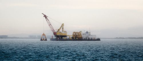Free A construction barge on a calm ocean near the Philippines during early morning. Stock Photo