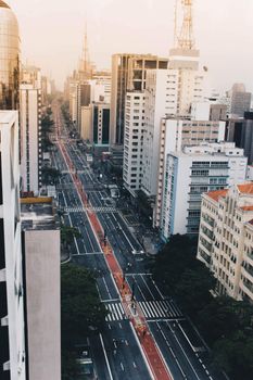 Stunning aerial view of a bustling cityscape with tall skyscrapers and roads at twilight.