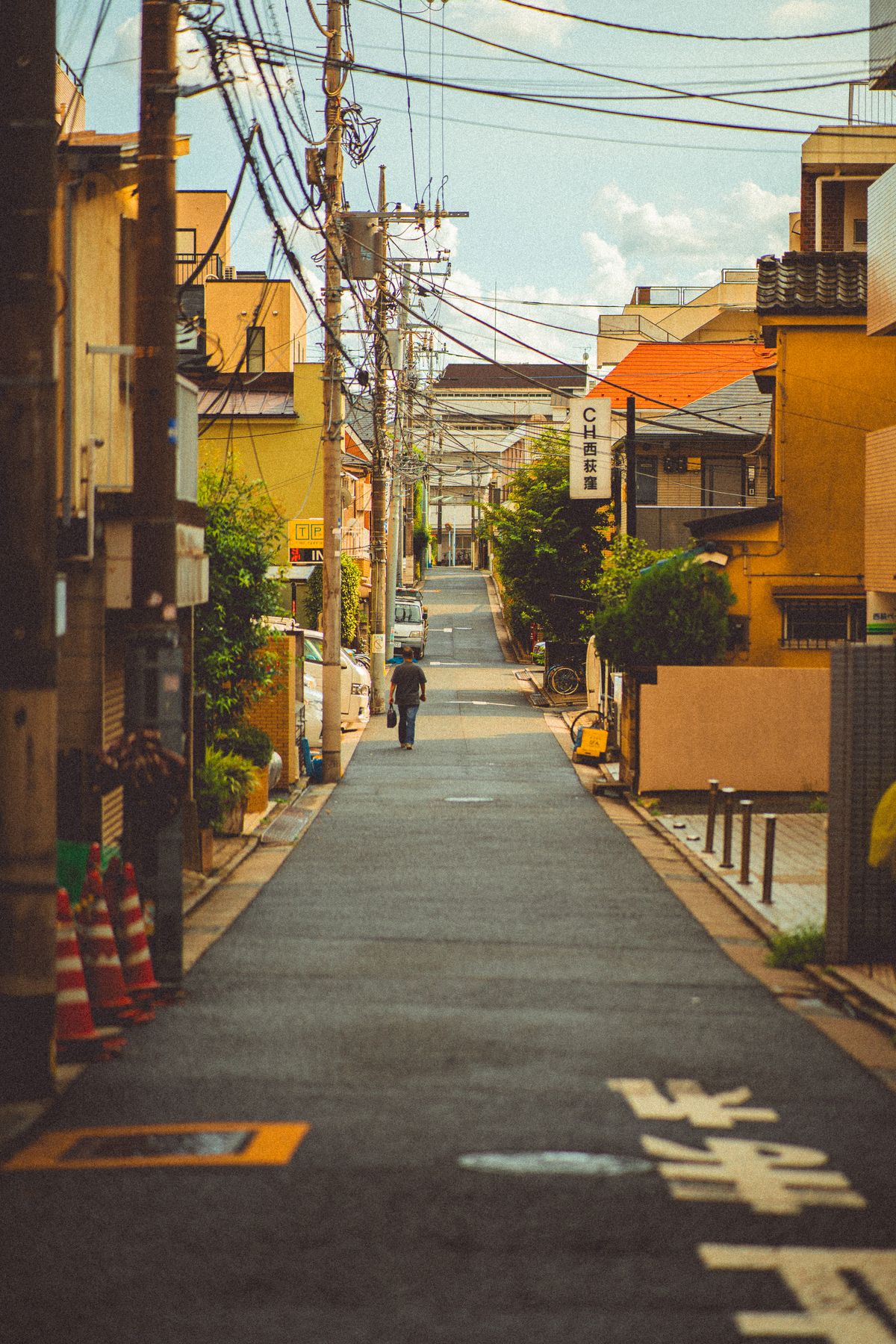 A quiet residential Tokyo back alley with power lines and small buildings
