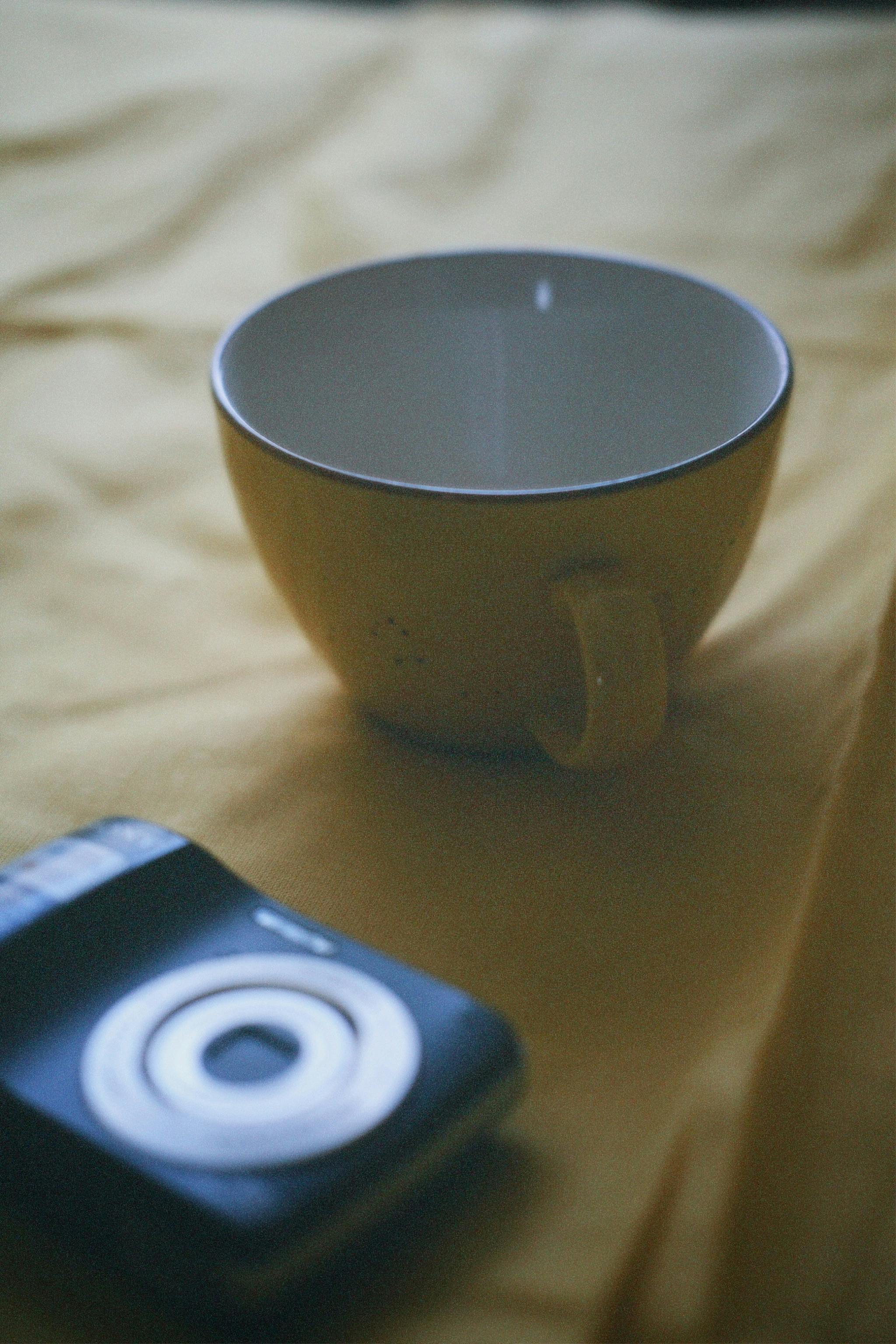 Empty Coffee Cup and Camera on Table · Free Stock Photo