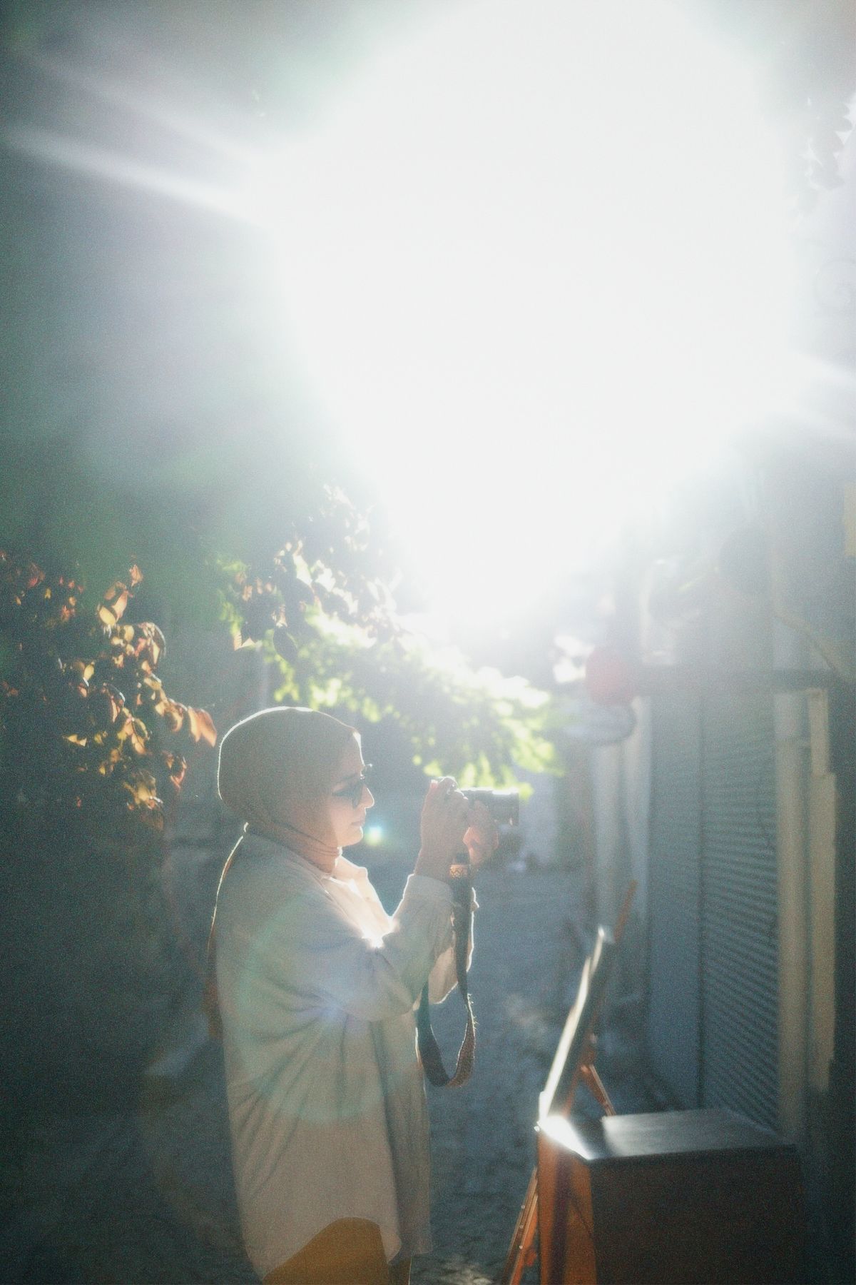 Person fotografiert draußen im Tageslicht mit einer Kamera.
