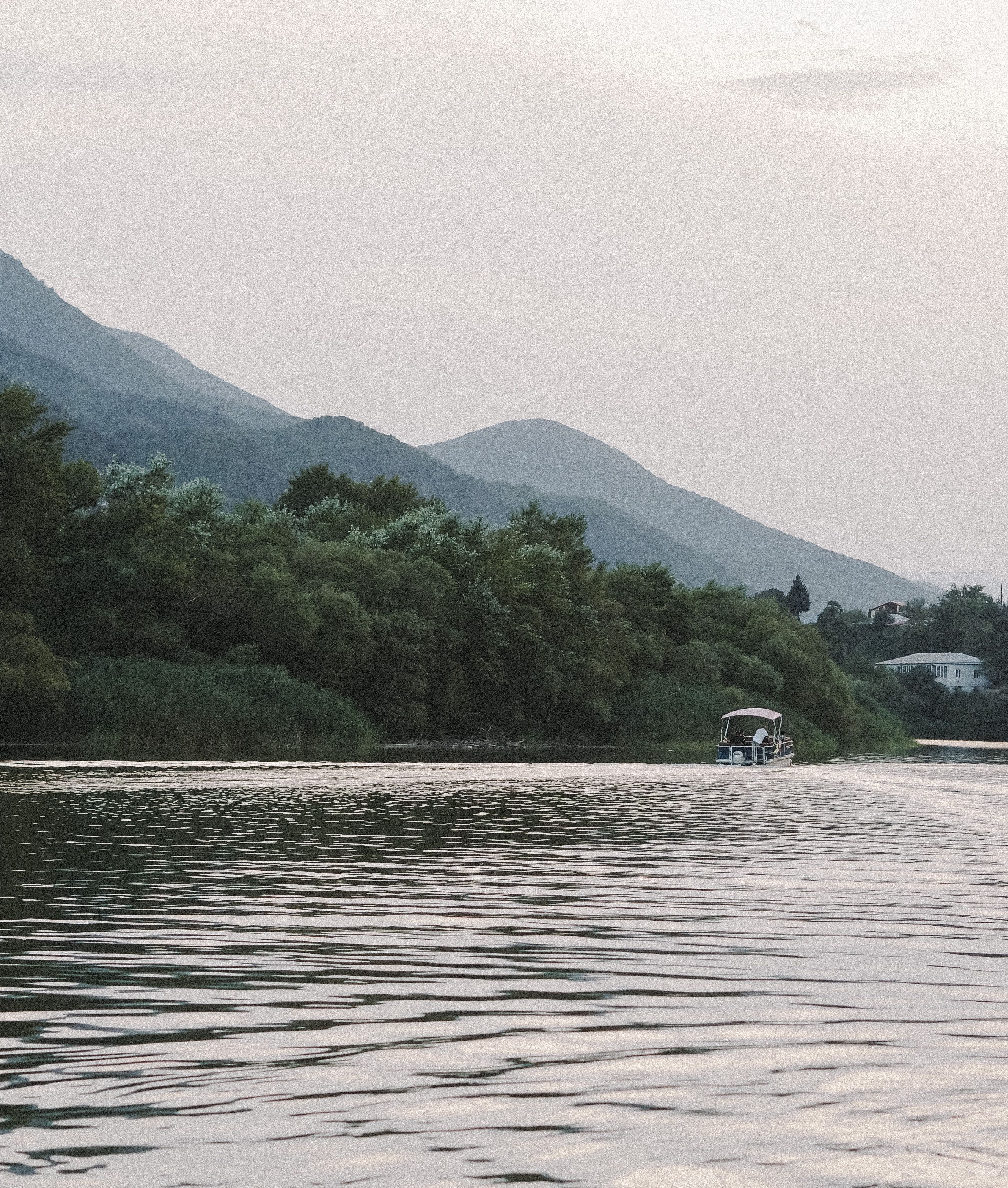 Motor Boat Sailing on a River in a Mountainous Landscape · Free Stock Photo