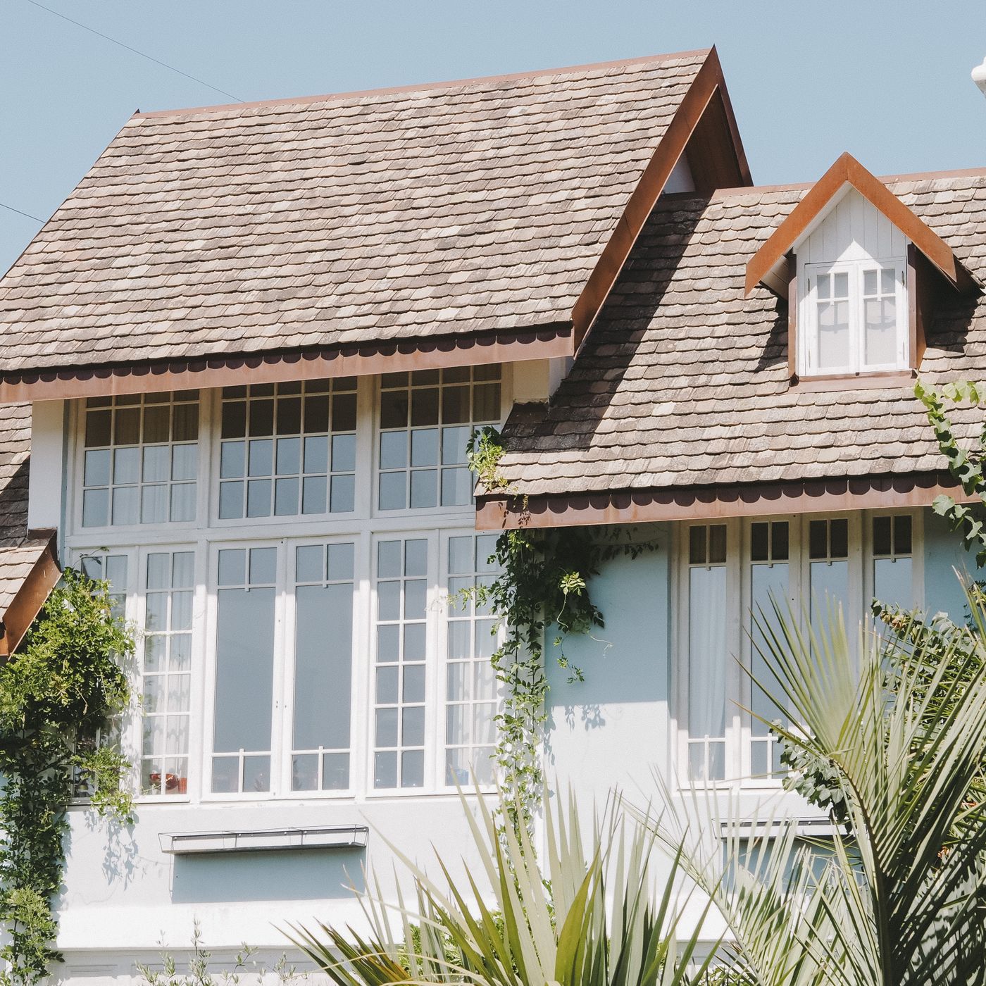A suburban house with a shingled roof and large windows
