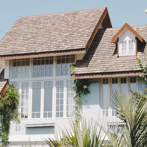 Free Elegant suburban house with large windows and a shingled slate roof in sunlight. Stock Photo