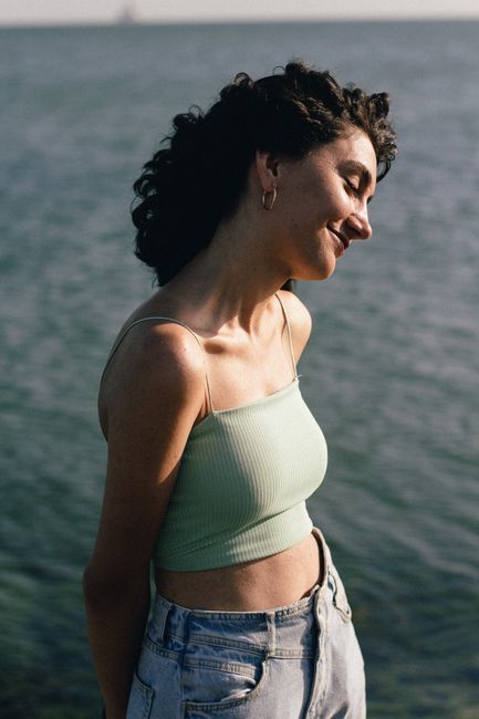 Portrait of a young woman in casual fashion smiling by the seaside.