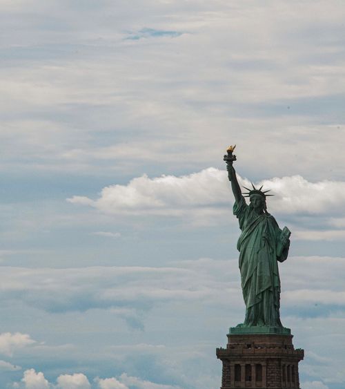 Free Scenic view of the Statue of Liberty with a cloudy sky backdrop, symbolizing freedom. Stock Photo