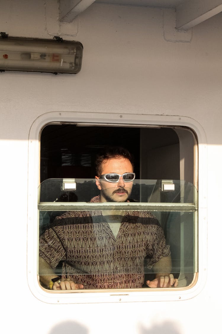 Passenger Looking Out The Ship Porthole