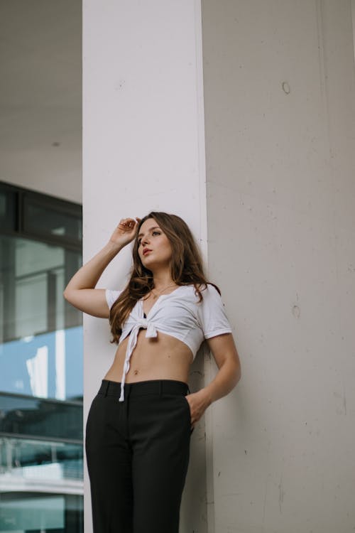 Woman in Tied Crop Top Leaning against Wall