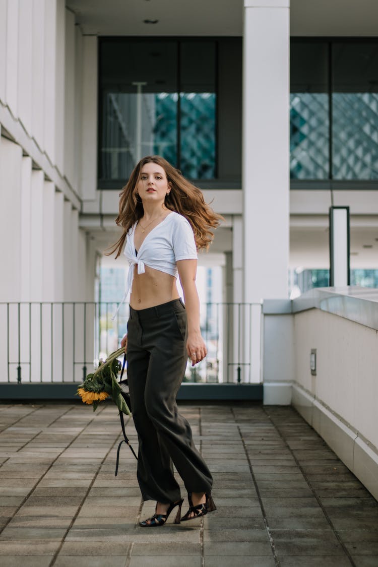 Woman In Tied Crop Top Holding Sunflower In Hand