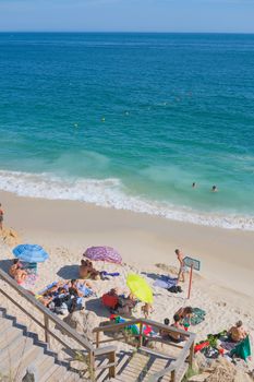 People enjoying a sunny day at Portinho da Arrábida in Setúbal, Portugal.