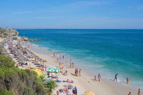 Free Relaxing scene of people enjoying the summer at Portinho da Arrábida beach, Portugal. Stock Photo