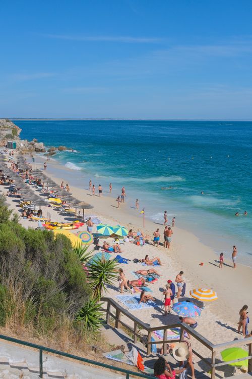 Free Beachgoers enjoying a sunny day at Portinho da Arrábida in Setubal, Portugal. Stock Photo