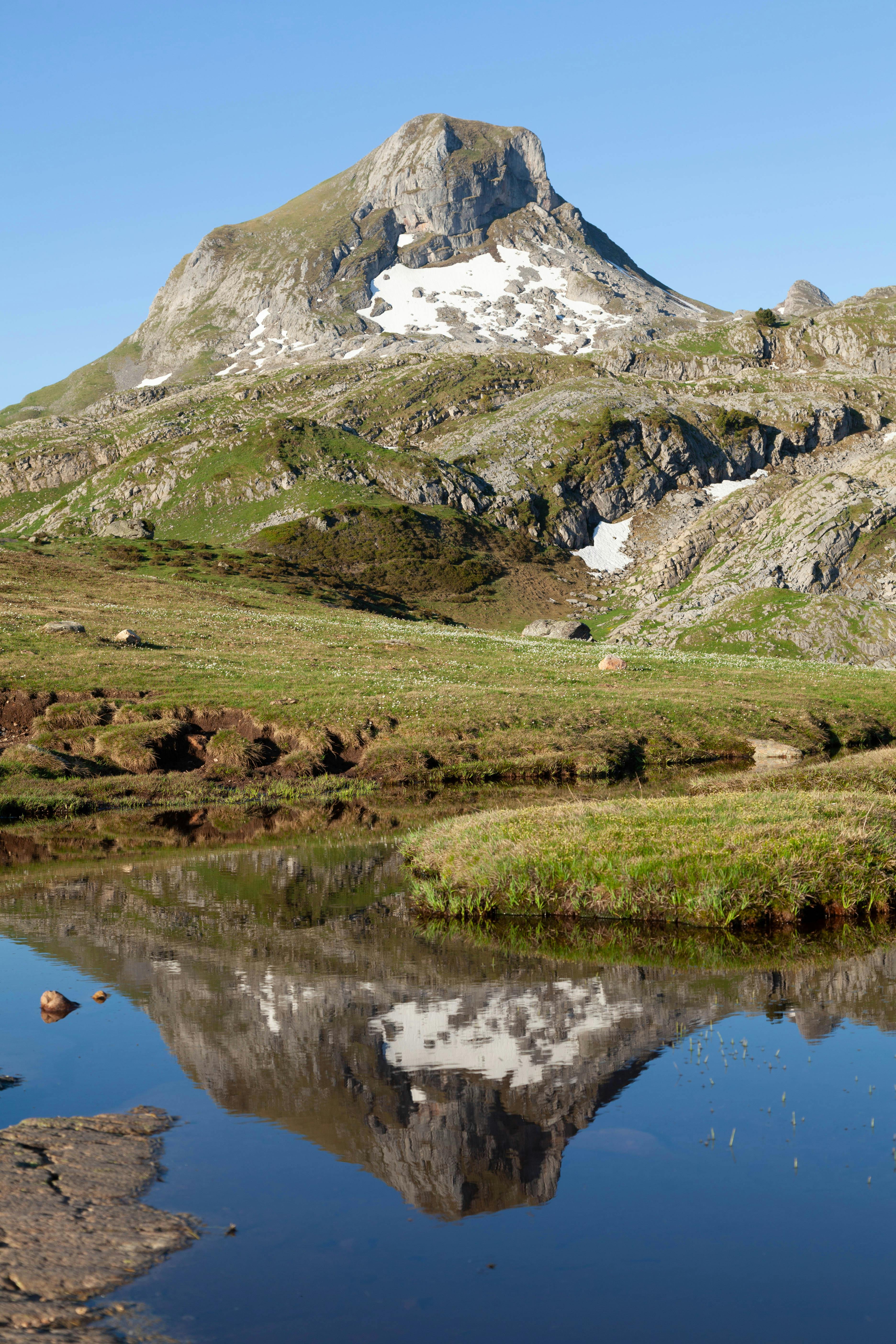 a mountain is reflected in a small pond