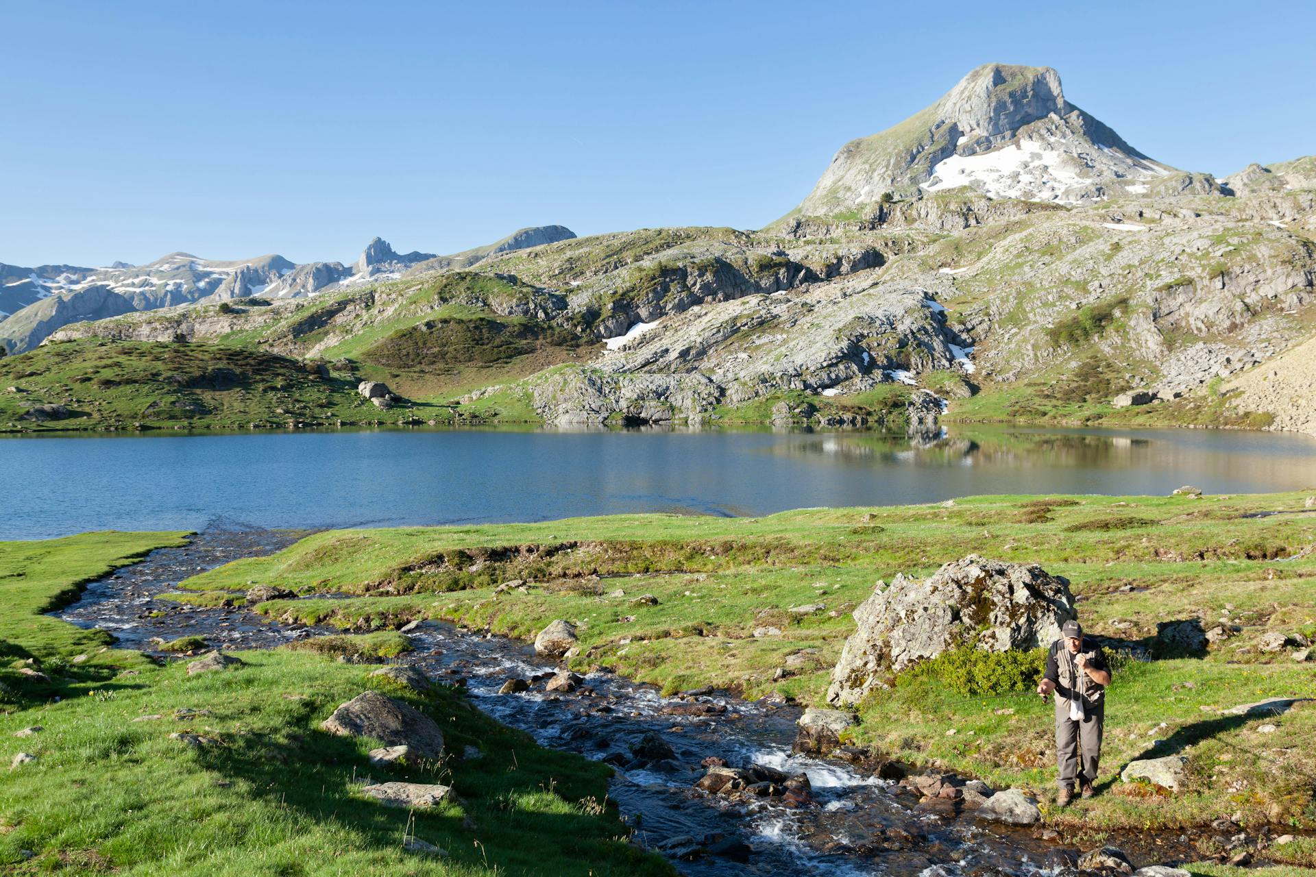 Angler Fishing in a Stream Above a Mountain Lake in the Pyrenees