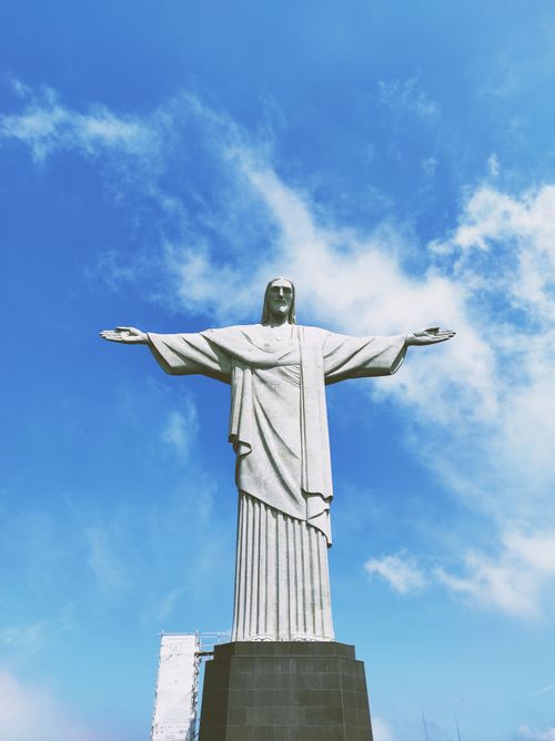 Free Iconic Christ the Redeemer statue with arms wide open against a clear blue sky in Rio de Janeiro. Stock Photo