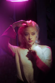 Young woman posing in dramatic purple lighting, captured in studio setting.