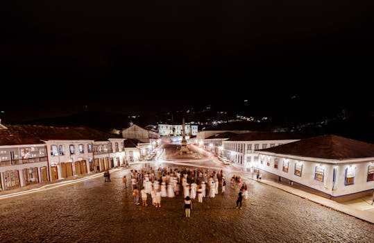 Captivating night shot of Ouro Preto town square, featuring illuminated colonial architecture and bustling crowd.