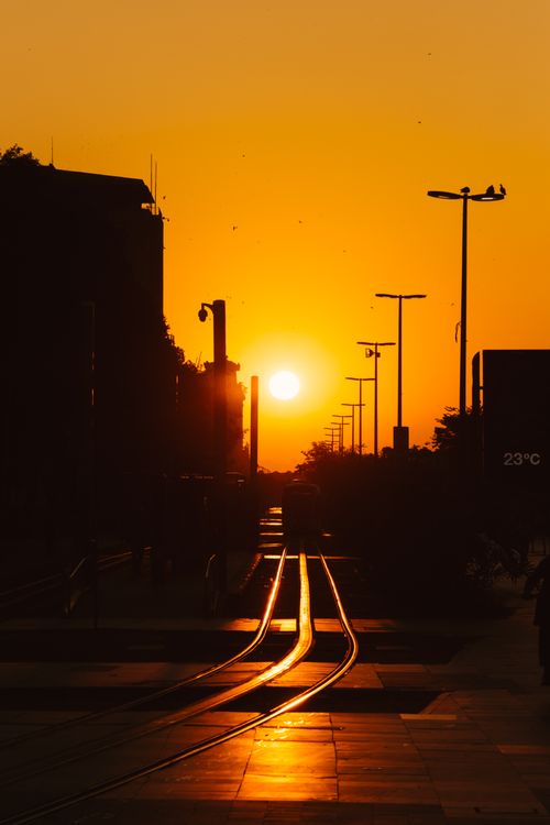 Free Silhouette of city buildings and railway tracks during a vibrant sunset in Rio de Janeiro. Stock Photo