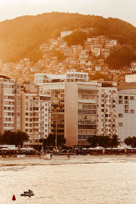 Discover the vibrant contrasts of Rio de Janeiro with this sunset view over Copacabana Beach and urban landscape.