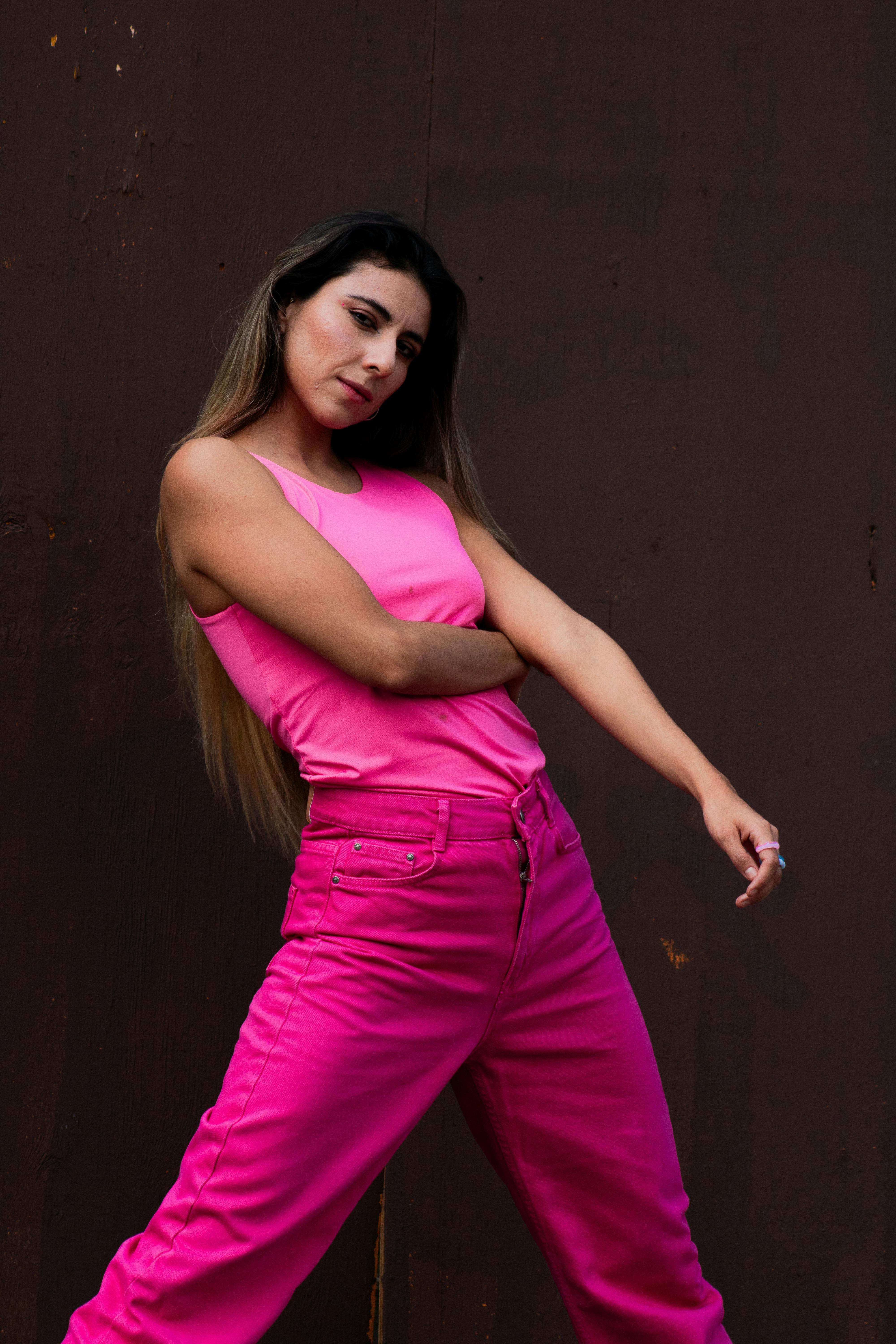 A woman in pink pants and a top posing for a photo · Free Stock Photo