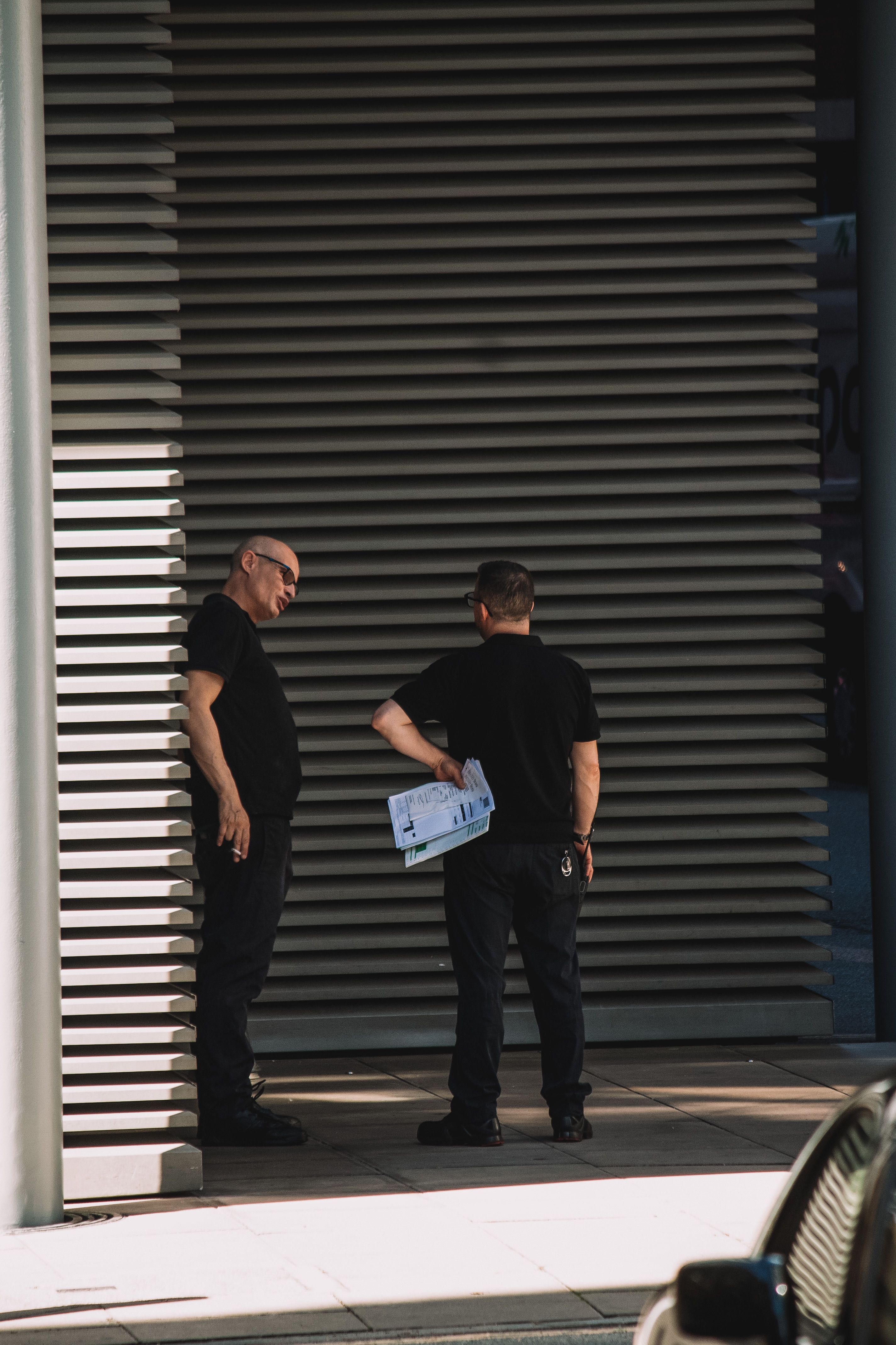 Security experts talking in an alleyway.