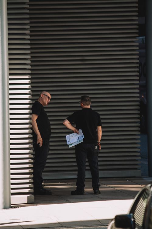 Security experts talking in an alleyway.